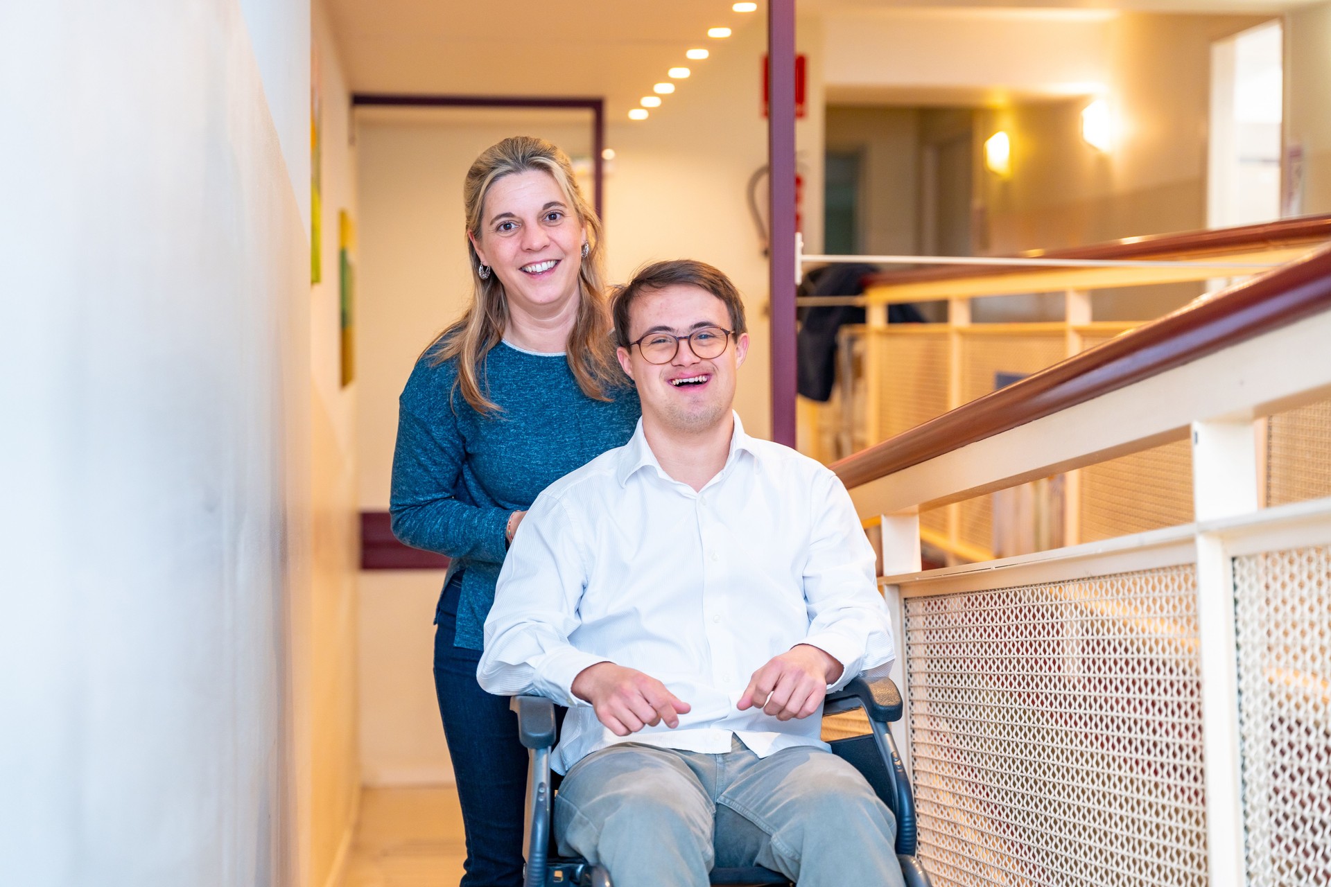 Happy caregiver and man with down syndrome on wheelchair